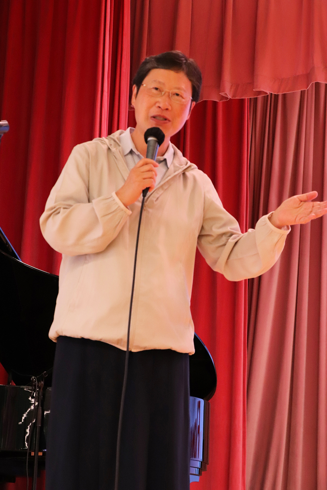 A person standing in front of a bannerDescription automatically generated